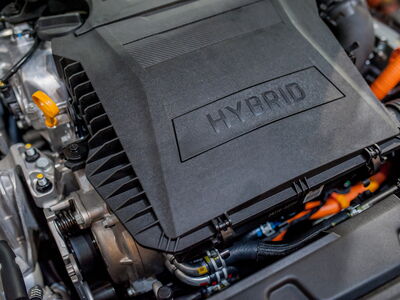 Nahaufnahme eines Hybridmotors mit deutlich sichtbarem "Hybrid"-Schriftzug auf der Abdeckung.
