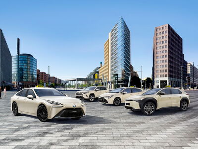 Eine Reihe von modernen Taxis steht vor urbaner Kulisse, die neue Taxi-Modelle f&uuml;r 2023 pr&auml;sentiert.