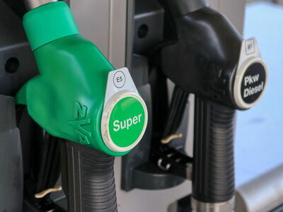 Gr&uuml;ne und schwarze Zapfpistolen f&uuml;r Superbenzin und Dieselkraftstoff an einer Tankstelle im Jahr 2022.